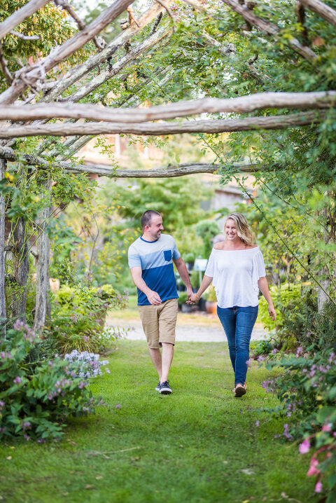 couple laughing and walking through arbor Kaitlyn Ferris engaged 