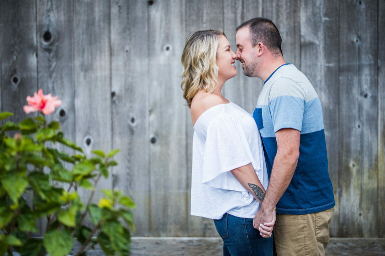 couple kissing in front of wood wall Kaitlyn Ferris engaged 