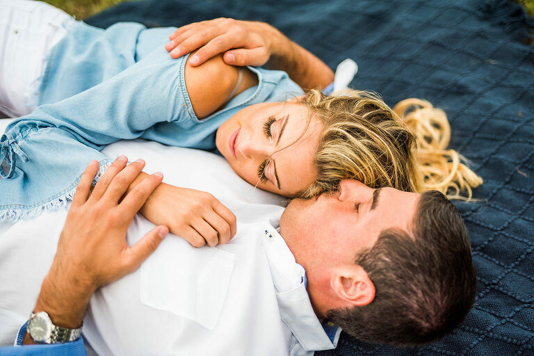 laying on a blanket kiss romantic engagement