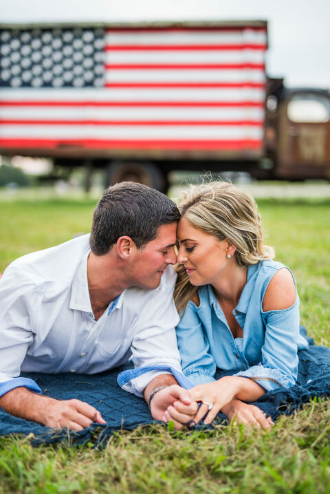 American flag truck in background forehead to forehead romantic engagement
