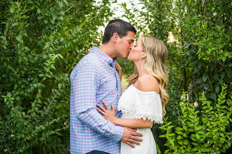 two people greenery romantic engagement kiss