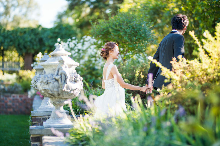 bride and groom walking through the flowers Kaitlyn Ferris photography garden wedding